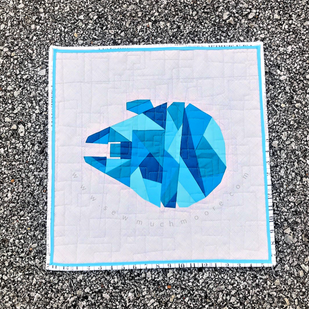 What's not to love about this modern geometric pattern? Let me tell you all about my Millennium Falcon Mini Quilt! You are going to love it! #Tutorial #Free #Pattern #Printables #Quilts #Pillows #Easy #Templates #Star #ForBeginners #Beginner #Art #Design #ArtDesign #Block #Hip #StarWars #MillenniumFalcon #MayTheFourthBeWithYou MayThe4thBeWithYou #Trendy #SewMuchMoore #SewMuchMooreInStore 